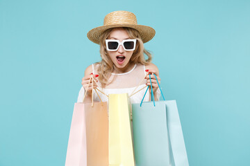 Shocked amazed young blonde woman 20s wearing white summer dress hat eyeglasses standing hold...
