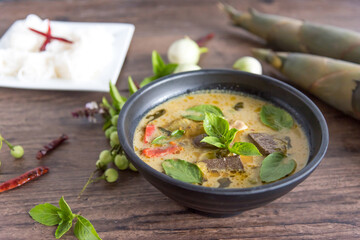 Chicken green curry with bamboo shoots and blood pudding (Kaeng kheiyw hwan) on dark wooden background with Thai tradition food served with steamed rice. Thai food very popular