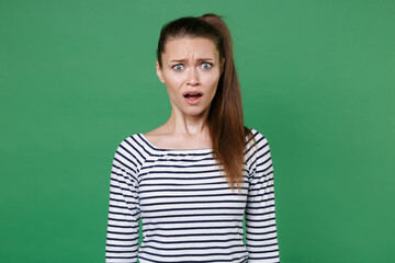 Shocked worried perplexed disgusted young brunette woman 20s wearing striped casual clothes posing...