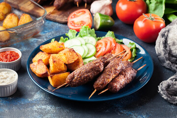 Grilled shish kebab served with fried potatoes