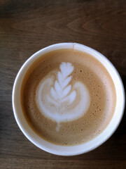 top view fresh coffee with milk foam art on a wooden background