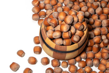 Filtered image of Hazelnuts in a wooden bowl on white background