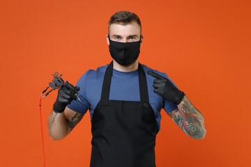 Professional tattooer master artist tattooed man in t-shirt apron pointing index finger on face...