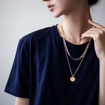 Closeup photo of yping woman wearing dark t-shirt and golden necklace