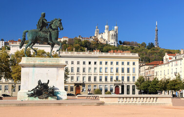 La statue de Louis IX sur  la place Bellecour à Lyon et la basilique de Fourvière en arrière plan.