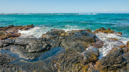 Beautiful shore. Large boulder among the waves in the sea. Hawaii