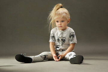 Naklejka premium Studio shot of 3 years old fashionable kid on the grey background 