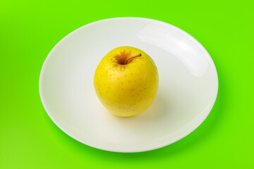 yellow Apple on a green background close-up.isolate