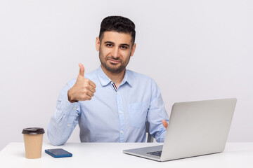 Well done, good job! Happy elegant businessman sitting office workplace, showing thumbs up, like...