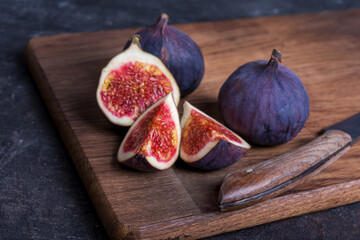 Fresh figs in wooden board  on dark background