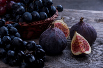Fresh figs and grapes on dark background
