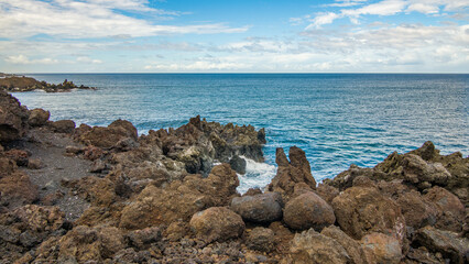 Beautiful shore. Large boulder among the waves in the sea. Hawaii