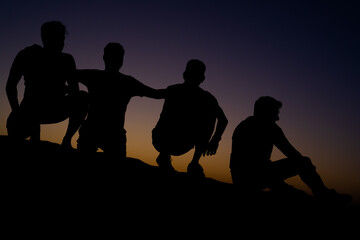 silhouettes of friends people, Friends sitting together at evening desert. friends sitting in desert at evening