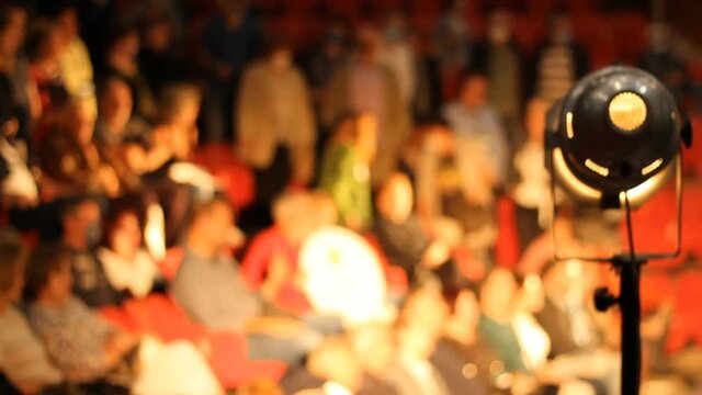 Reflector Light Audience in cinema theater unrecognizable people out of focus