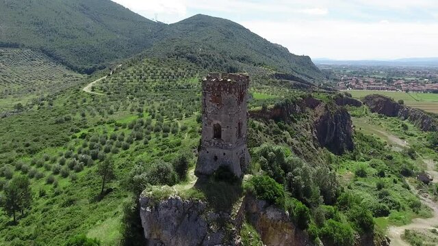 Aerial view of medieval tower on the top of the mountain. Drone viewpoint. Slow motion