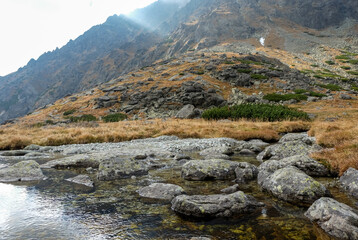  Pond in Valley of Five Spis Lakes surrounded by rocky summits, High Tatra Mountains, Slovakia.