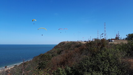 September 26, 2020 Russia Anapa. Paragliding competitions over the sea. Against the backdrop of a TV tower and a clear blue sky.