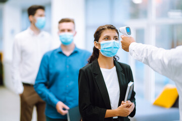 Disease control experts use an Infrared thermometer equipment to check the temperature on the...