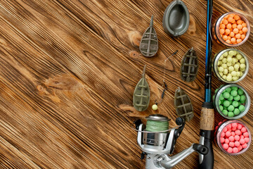 Fototapeta na wymiar Accessories for carp fishing and fishing baits on wooden planks with copy space