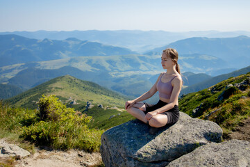 Naklejka na ściany i meble Yoga, Meditation. Woman balanced, practicing meditation and zen energy yoga in mountains. Girl doing fitness exercise sport outdoors in morning. Healthy lifestyle concept.