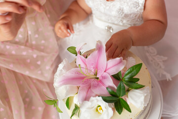first cake. pink cake. the child takes the cake with his hand. hand in pastry cream. children's holiday