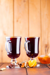 Mulled wine on a wooden boards. Autumn mulled wine, spices and honey. Christmas hot drink in rustic style