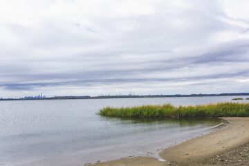 bay with sand and grass at Jamaica bay wildlife refuge with nyc background