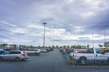 Fototapeta na wymiar Queens, NY / USA - September 26 2020: Outdoor car parking in an asphalt lot with trees in the background