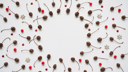 Pattern of cones, white snowflakes, red balls and stars on a white background, top view, flat lay, copy space.Christmas and New Year background and greeting card concept
