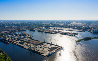 Fototapeta premium Aerial view of cargo ship, cargo container in warehouse harbor in the Morskie Vorota district in St. Petersburg
