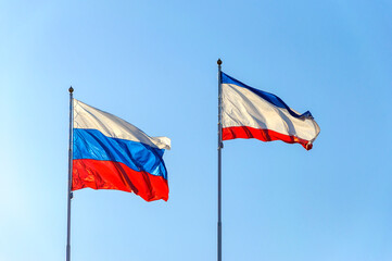 Flags of the Russian Federation and the Republic of Crimea on flagpoles. The symbol of unity.