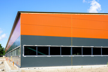 new metal frame factory building, covered with sandwich panels against a blue sky