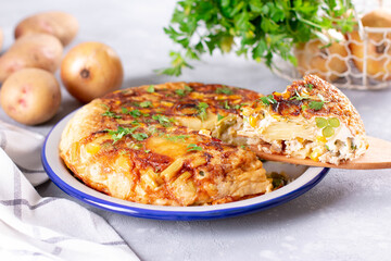 Slice of Spanish potato tortilla on light background - delicious breakfast or snack