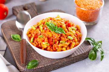 Soup with lentils, carrots, vegetables and basil, in a plate on a board. Indian vegetarian cuisine.