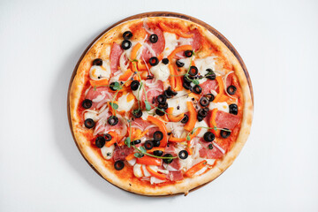 Italian pizza with olives, peppers and herbs on white background.