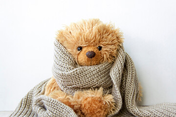 Toy bear in a warm scarf. Season of colds and infections.