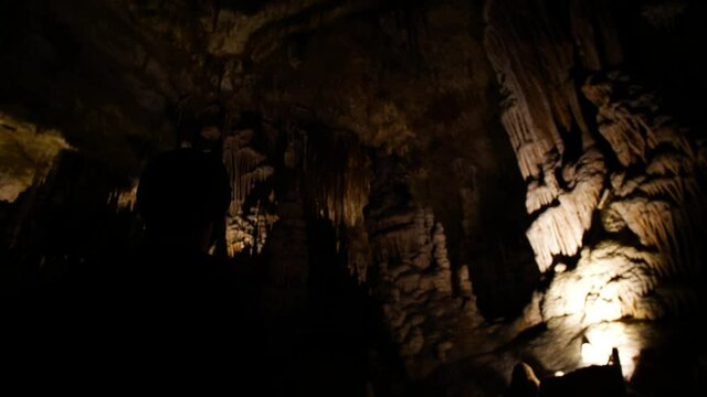 Man in low key overlooking cave's iluminated roof.
High angle, parallax movement, 4k 60p.