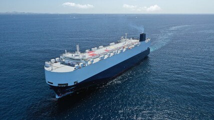 Fototapeta na wymiar Aerial drone photo of huge car carrier ship RO-RO (Roll on Roll off) cruising in Mediterranean deep blue Aegean sea