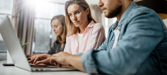 Fototapeta premium Group of young people working or studying together. Hipster team in coworking. Young modern business colleagues. Startup concept