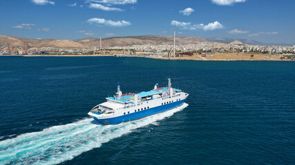 Fototapeta na wymiar Aerial drone photo of passenger ferry cruising in high speed and entering famous port of Piraeus, Attica, Greece