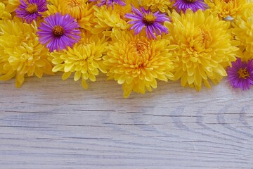 Floral frame of chrysanthemums on a white wooden background. View from above. Background with copy space.