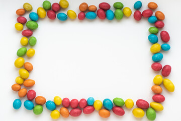 Fototapeta premium frame from multicolored candies with place for text on white background