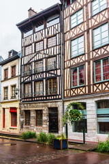 Typical Old Half-timbered houses at Rue Eau de Robec in Rouen on a rainy day. Rue Eau-de-Robec is one of the main tourist streets of Rouen. Upper Normandy, France.
