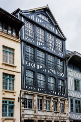Fototapeta premium Typical Old Half-timbered houses at Rue Eau de Robec in Rouen on a rainy day. Rue Eau-de-Robec is one of the main tourist streets of Rouen. Upper Normandy, France.