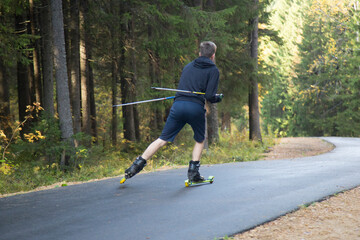 Men ride roller skis in the autumn Park.