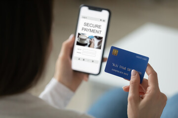 Close up back view of woman use modern cellphone gadget make secure online payment with credit card. Female client buyer pay shop on internet on smartphone, use bank service system or application.