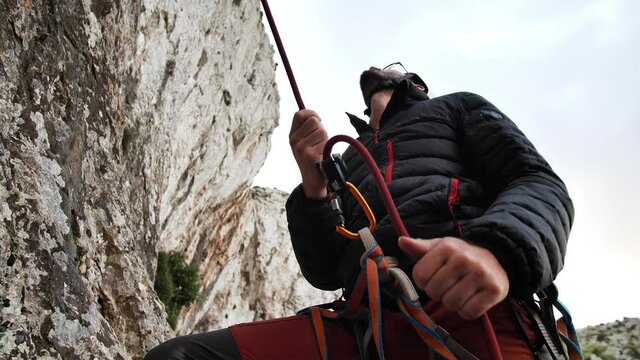 Man retrieving rope while belaying his climbing partner in Betlem, Mallorca, Spain.
High angle, parallax movement, 4K 60p.