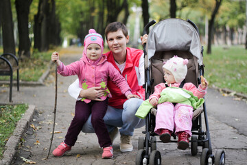 mom walks with two daughters in the autumn park