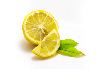 Lemon cutaway composition with greens with leaves and slice on white isolated background