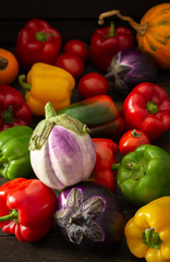 Fresh autumn harvest of organic vegetables, bell peppers with tomatoes, eggplant and pumpkin, vegetable background
